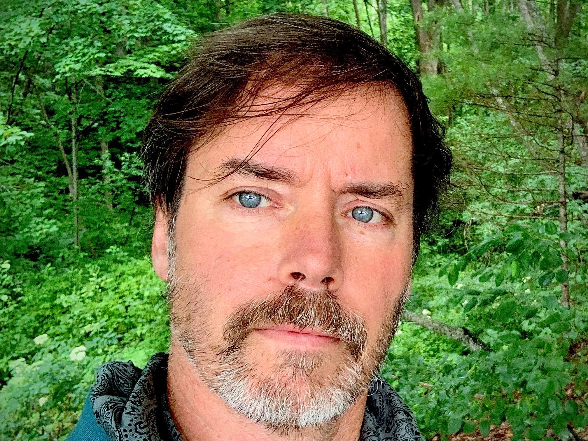 Headshot of Patrick Bonsent with a forest background